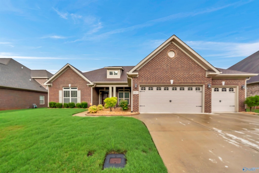 view of front of home featuring brick siding, concrete driveway, a garage, and a front lawn