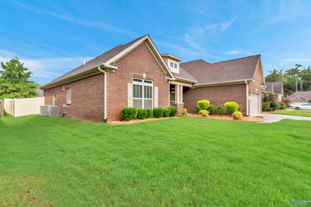 view of front of property with a garage, central AC, and a front yard