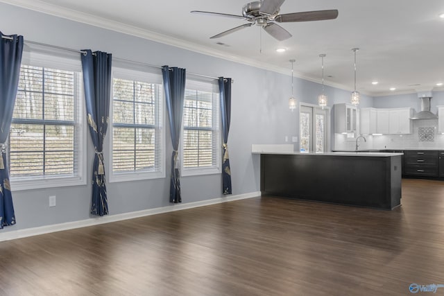 kitchen with wall chimney exhaust hood, dark hardwood / wood-style flooring, white cabinets, and pendant lighting