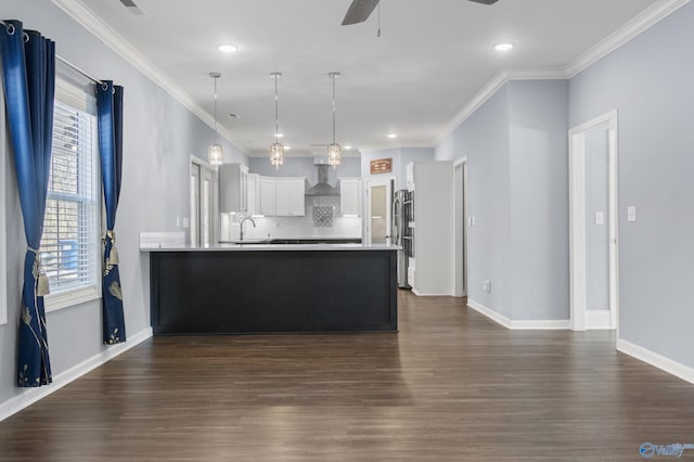 kitchen with white cabinets, pendant lighting, a healthy amount of sunlight, and wall chimney range hood