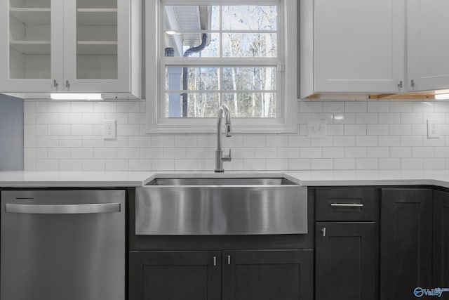 kitchen featuring white cabinets, dishwasher, backsplash, and sink