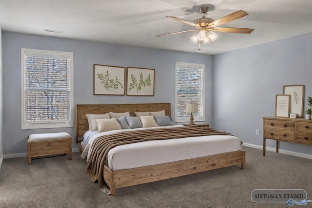 carpeted bedroom featuring multiple windows and ceiling fan