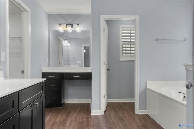 bathroom with a bath, wood-type flooring, and vanity