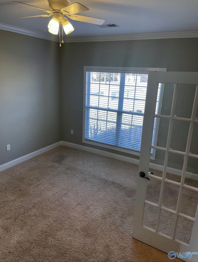 carpeted spare room featuring crown molding and ceiling fan