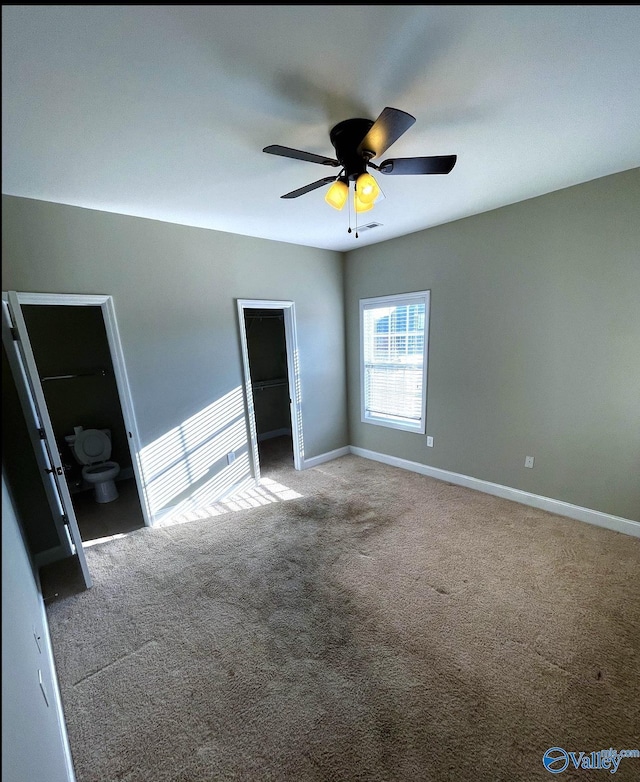 unfurnished bedroom featuring ensuite bathroom, carpet flooring, ceiling fan, and a closet