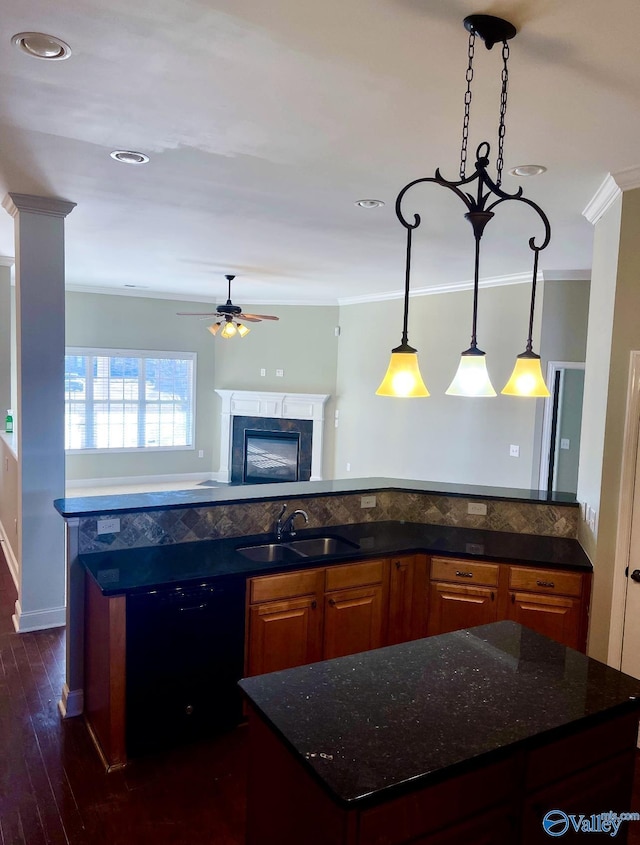 kitchen with sink, a tile fireplace, dishwasher, dark stone countertops, and ornamental molding