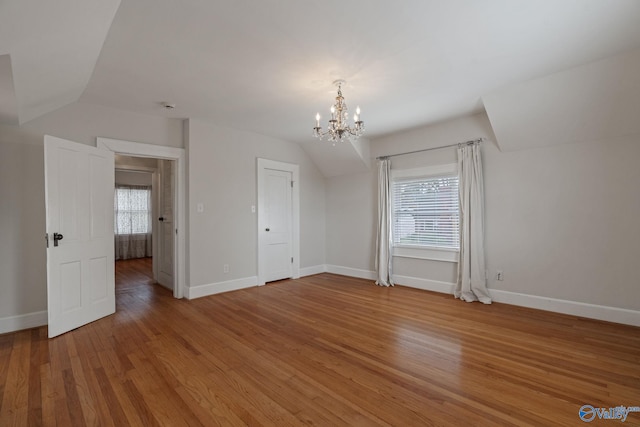 additional living space with hardwood / wood-style floors, plenty of natural light, and vaulted ceiling