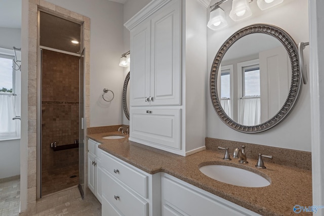 bathroom featuring vanity, a tile shower, and plenty of natural light