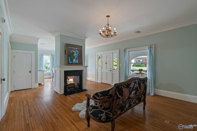 living room with a multi sided fireplace, crown molding, hardwood / wood-style flooring, and plenty of natural light