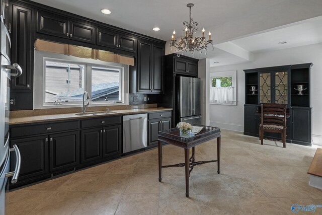 kitchen featuring appliances with stainless steel finishes, decorative light fixtures, sink, and a wealth of natural light