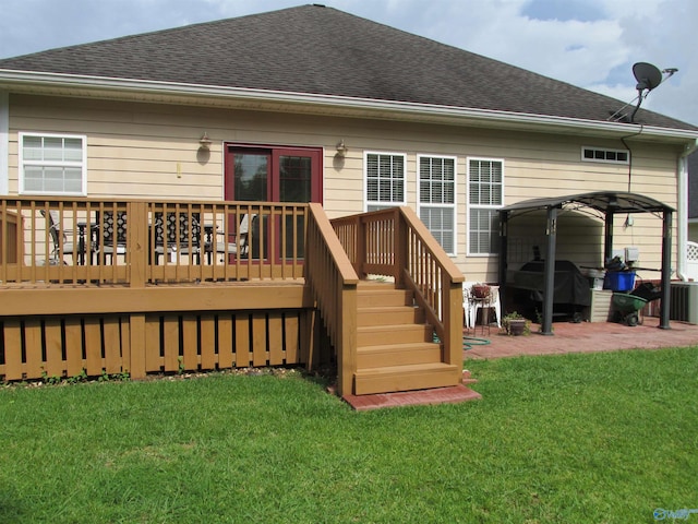 rear view of property with a deck and a lawn