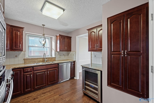 kitchen with beverage cooler, dishwasher, tasteful backsplash, sink, and hanging light fixtures