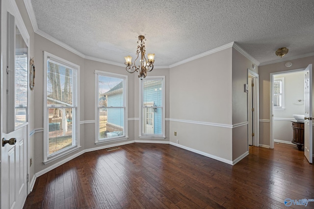 unfurnished dining area featuring a textured ceiling, dark wood-type flooring, a chandelier, and crown molding