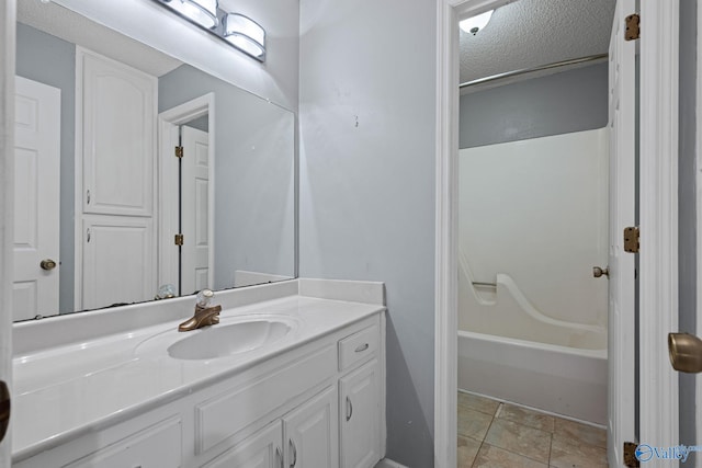 bathroom featuring tub / shower combination, a textured ceiling, and vanity