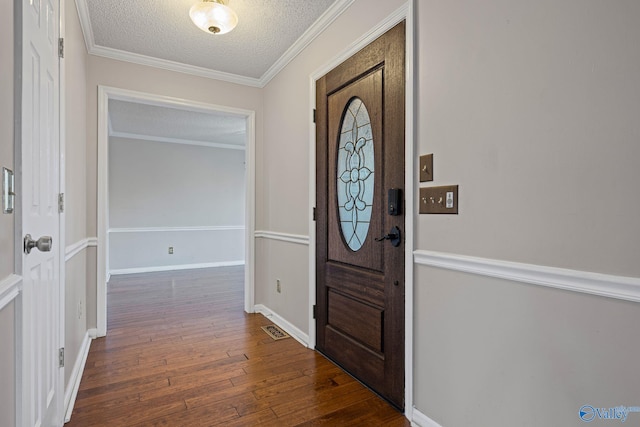 entryway featuring dark hardwood / wood-style flooring, a textured ceiling, and ornamental molding