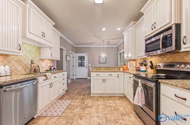 kitchen with backsplash, crown molding, a peninsula, stainless steel appliances, and a sink