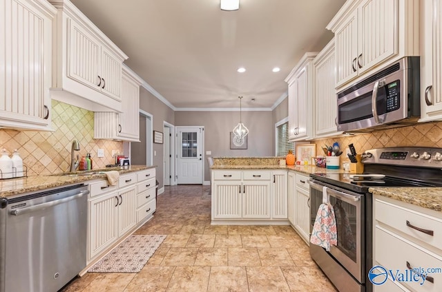 kitchen with ornamental molding, decorative backsplash, appliances with stainless steel finishes, a peninsula, and a sink