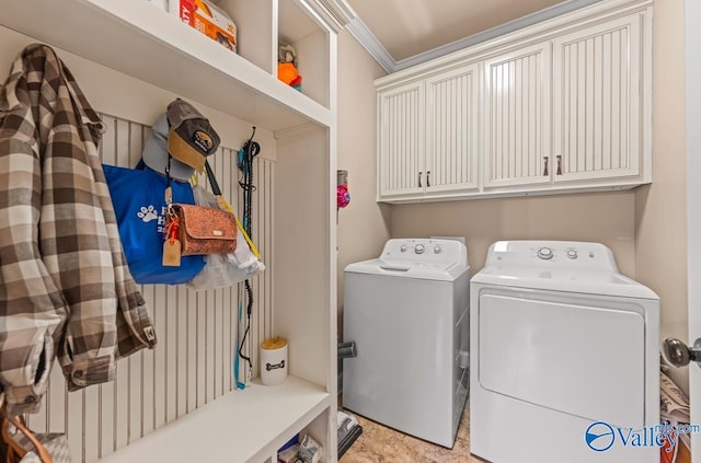 washroom featuring cabinet space, crown molding, and washing machine and dryer