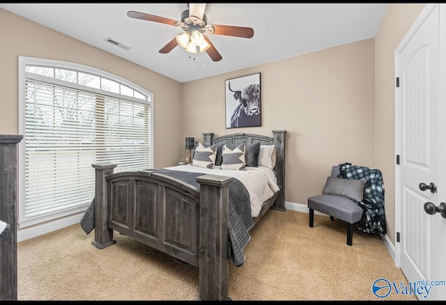 bedroom with light carpet, visible vents, ceiling fan, and baseboards