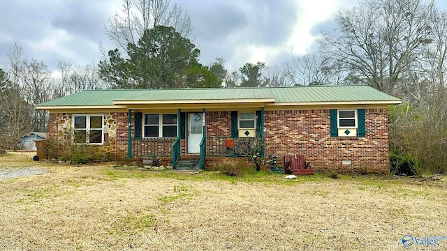 ranch-style house featuring metal roof, brick siding, a porch, and a front lawn