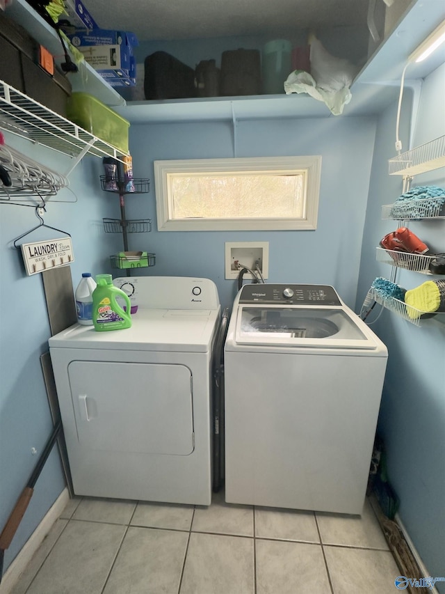 laundry area with light tile patterned flooring, laundry area, and washing machine and clothes dryer