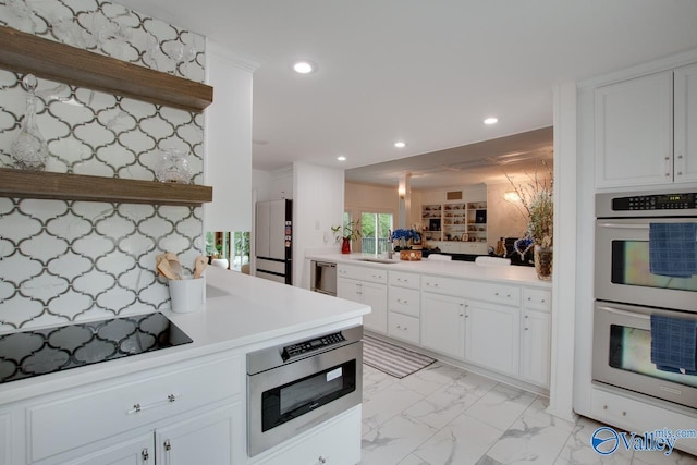 kitchen with white cabinets, appliances with stainless steel finishes, decorative backsplash, and sink