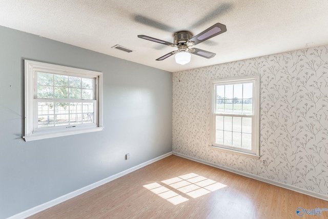 spare room with ceiling fan, a textured ceiling, and light hardwood / wood-style flooring