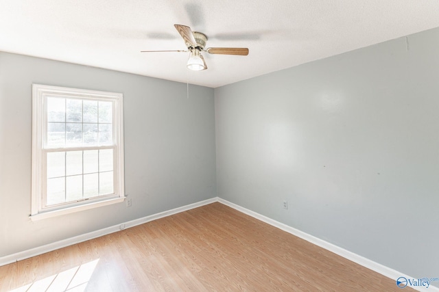 spare room with light wood-type flooring, ceiling fan, and a textured ceiling