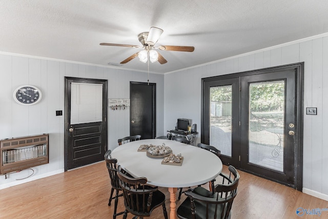 dining room with ornamental molding, heating unit, and light hardwood / wood-style floors