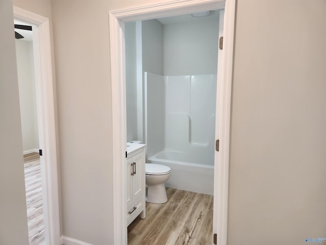 full bath featuring toilet, bathing tub / shower combination, wood finished floors, and vanity