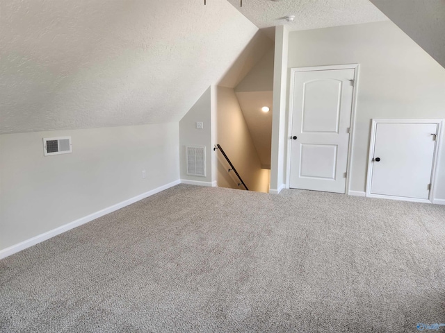 bonus room with carpet floors, visible vents, and a textured ceiling