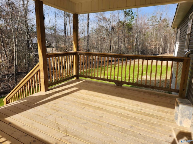 wooden deck with a yard and a forest view