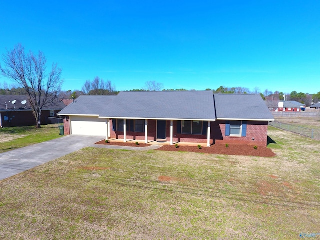 single story home featuring a porch, concrete driveway, brick siding, and a front yard