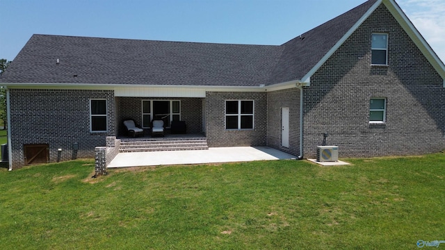 rear view of property with a patio, a yard, a shingled roof, central air condition unit, and brick siding