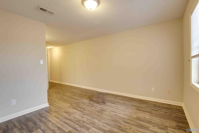 403 Rooks St, Hartselle, AL 35640 - empty room featuring visible vents, a textured ceiling, baseboards, and wood finished floors