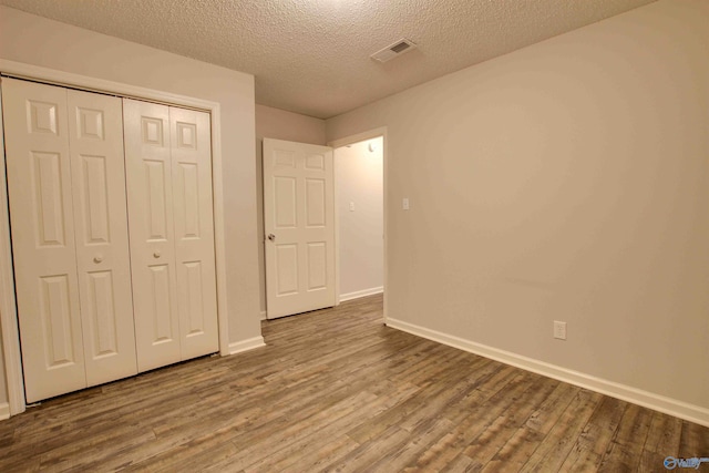 403 Rooks St, Hartselle, AL 35640 - unfurnished bedroom with a textured ceiling, a closet, wood finished floors, and baseboards