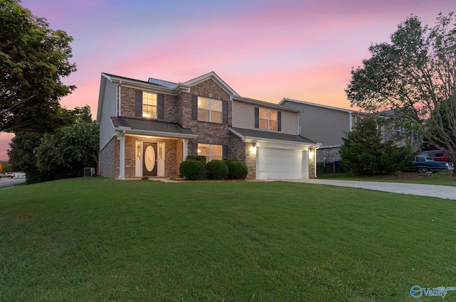 view of property with a garage, central AC unit, and a lawn