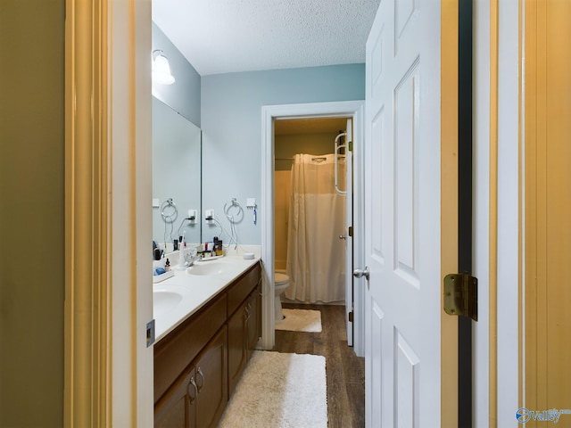 bathroom featuring vanity, toilet, a textured ceiling, and hardwood / wood-style flooring