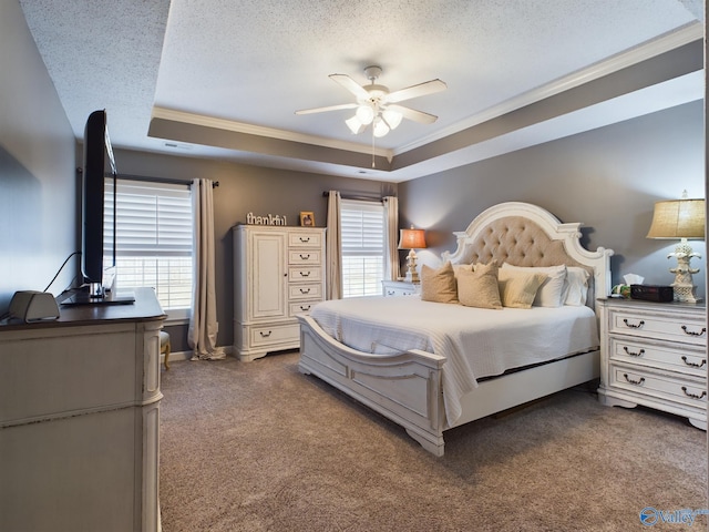 bedroom with multiple windows, a raised ceiling, dark carpet, and ceiling fan