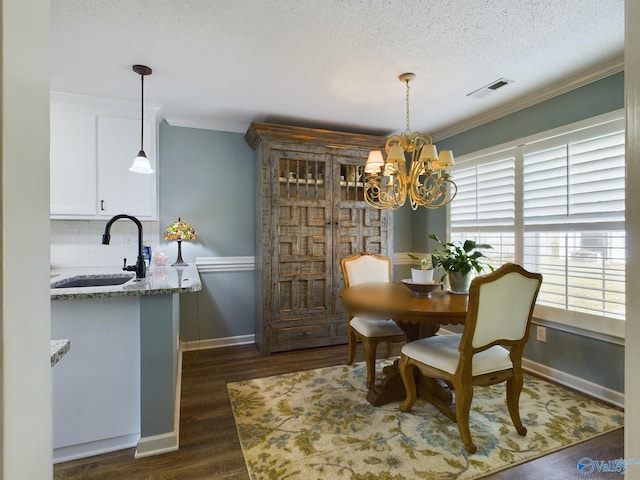 dining space with a chandelier, a textured ceiling, sink, dark hardwood / wood-style flooring, and ornamental molding