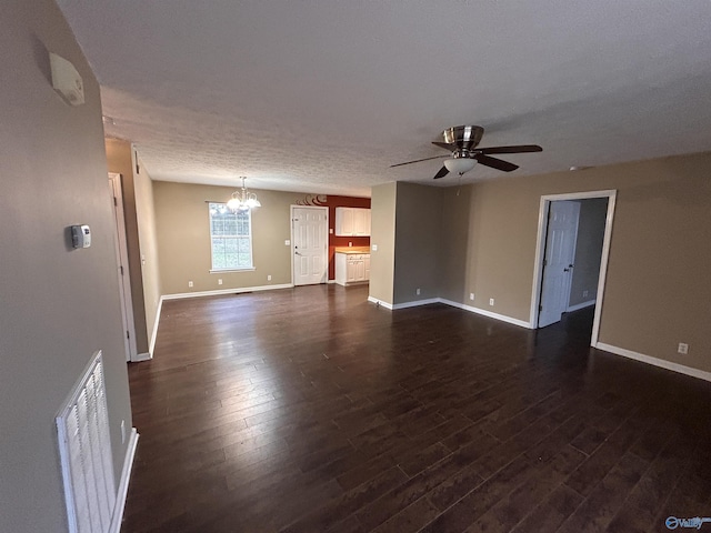 spare room with a textured ceiling, ceiling fan with notable chandelier, and dark hardwood / wood-style floors