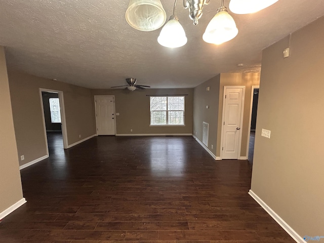 spare room with dark hardwood / wood-style flooring and ceiling fan with notable chandelier