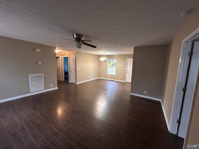 spare room featuring ceiling fan with notable chandelier, a textured ceiling, and dark wood-type flooring