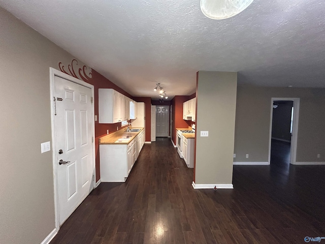 kitchen featuring white cabinets, a textured ceiling, dark wood-type flooring, and sink