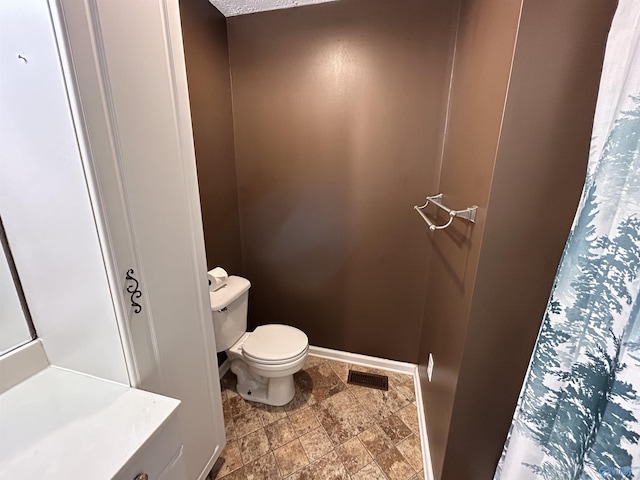 bathroom with a textured ceiling and toilet