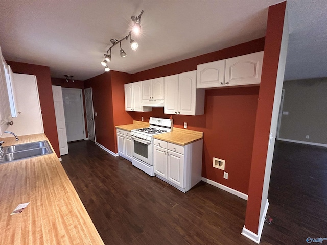 kitchen with butcher block counters, gas range gas stove, sink, dark wood-type flooring, and white cabinets