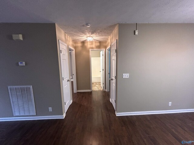 hall featuring dark hardwood / wood-style floors and a textured ceiling