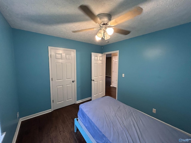 bedroom with ceiling fan, dark hardwood / wood-style flooring, and a textured ceiling