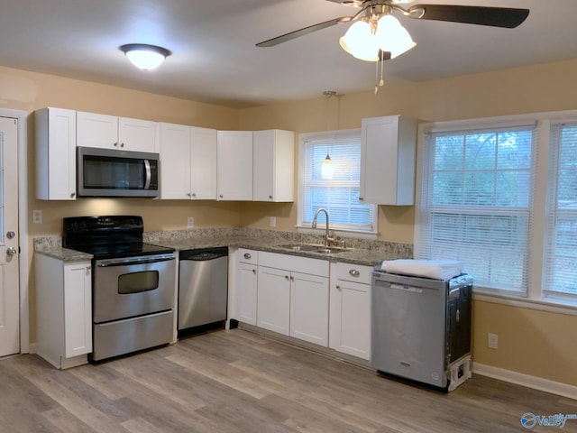 kitchen featuring white cabinets, light hardwood / wood-style floors, sink, and appliances with stainless steel finishes