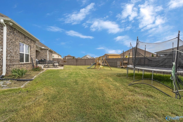 view of yard with a trampoline, a playground, and a patio area